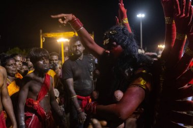 Kulashekharapatnam, Tamilnadu, Hindistan - 11 Ekim 2024: Hint Hindu dindar, yüzü boyalı ve tarikat karakteri gibi giyinmiş, kulasai dasara festivalini akşam ateşle gerçekleştirmek için.