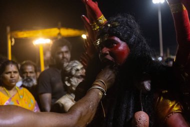 Kulashekharapatnam, Tamilnadu, Hindistan - 11 Ekim 2024: Hint Hindu dindar, yüzü boyalı ve tarikat karakteri gibi giyinmiş, kulasai dasara festivalini akşam ateşle gerçekleştirmek için.