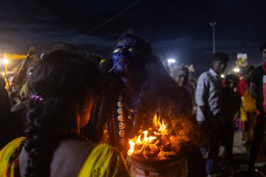 Kulashekharapatnam, Tamilnadu, Hindistan - 11 Ekim 2024: Hint Hindu dindar, yüzü boyalı ve tarikat karakteri gibi giyinmiş, kulasai dasara festivalini akşam ateşle gerçekleştirmek için.