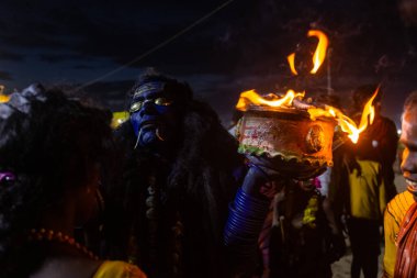 Kulashekharapatnam, Tamilnadu, Hindistan - 11 Ekim 2024: Hint Hindu dindar, yüzü boyalı ve tarikat karakteri gibi giyinmiş, kulasai dasara festivalini akşam ateşle gerçekleştirmek için.
