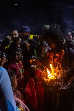 Kulashekharapatnam, Tamilnadu, Hindistan - 11 Ekim 2024: Hint Hindu dindar, yüzü boyalı ve tarikat karakteri gibi giyinmiş, kulasai dasara festivalini akşam ateşle gerçekleştirmek için.