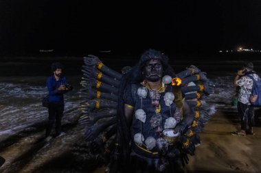 Kulashekharapatnam, Tamilnadu, Hindistan - 11 Ekim 2024: Hint Hindu dindar, yüzü boyalı ve tarikat karakteri gibi giyinmiş, kulasai dasara festivalini akşam ateşle gerçekleştirmek için.