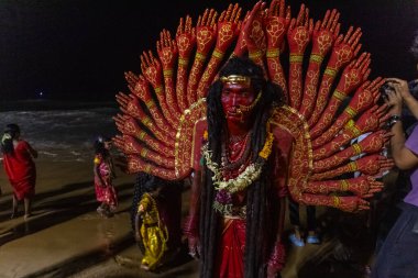 Kulashekharapatnam, Tamilnadu, Hindistan - 11 Ekim 2024: Hint Hindu dindar, yüzü boyalı ve tarikat karakteri gibi giyinmiş, kulasai dasara festivalini akşam ateşle gerçekleştirmek için.