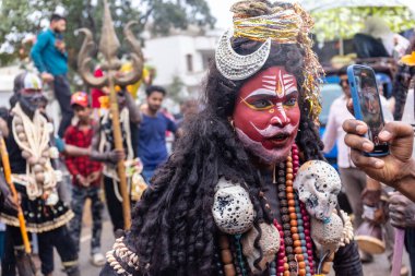 Varanasi, Uttar Pradesh, Hindistan - 20 Mart 2024: Masan Holi, Masan Holi, Masan Holi, Harishchandra ghat 'taki masaan holi kutlamaları sırasında tanrıça Kali olarak resmedilen bir kadın ressamın portresi.