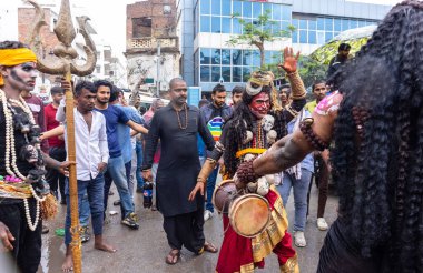 Varanasi, Uttar Pradesh, Hindistan - 20 Mart 2024: Masan Holi, Masan Holi, Masan Holi, Harishchandra ghat 'taki masaan holi kutlamaları sırasında tanrıça Kali olarak resmedilen bir kadın ressamın portresi.