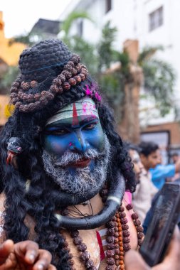 Varanasi, Uttar Pradesh, Hindistan - 20 Mart 2024: Masan Holi, Masan Holi, Masan Holi, Harishchandra ghat 'taki masaan holi kutlamaları sırasında tanrıça Kali olarak resmedilen bir kadın ressamın portresi.