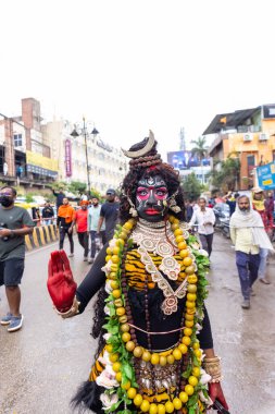 Varanasi, Uttar Pradesh, Hindistan - 20 Mart 2024: Masan Holi, Masan Holi, Masan Holi, Harishchandra ghat 'taki masaan holi kutlamaları sırasında tanrıça Kali olarak resmedilen bir kadın ressamın portresi.