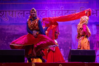 Pushkar, Rajasthan, Hindistan - 11 Kasım 2024: Bhangra, Sih erkek sanatçılar grubu renkli etnik elbiseler içinde bhangra dansı yapıyorlar..