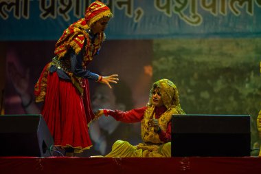 Pushkar, Rajasthan, Hindistan - 11 Kasım 2024: Bhangra, Sih erkek sanatçılar grubu renkli etnik elbiseler içinde bhangra dansı yapıyorlar..
