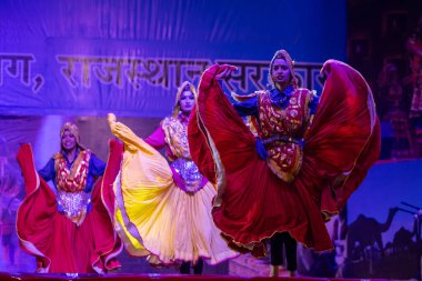 Pushkar, Rajasthan, Hindistan - 11 Kasım 2024: Bhangra, Sih erkek sanatçılar grubu renkli etnik elbiseler içinde bhangra dansı yapıyorlar..