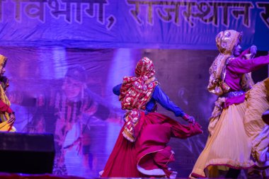 Pushkar, Rajasthan, Hindistan - 11 Kasım 2024: Bhangra, Sih erkek sanatçılar grubu renkli etnik elbiseler içinde bhangra dansı yapıyorlar..