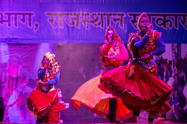 Pushkar, Rajasthan, Hindistan - 11 Kasım 2024: Bhangra, Sih erkek sanatçılar grubu renkli etnik elbiseler içinde bhangra dansı yapıyorlar..