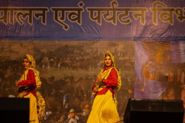 Pushkar, Rajasthan, Hindistan - 11 Kasım 2024: Bhangra, Sih erkek sanatçılar grubu renkli etnik elbiseler içinde bhangra dansı yapıyorlar..