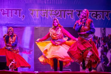 Puşkar, Rajasthan, Hindistan - 11 Kasım 2024: Bhangra, Bhangra grubu, açık hava kültür gecesi renkli etnik elbiseler içinde bhangra dansı yapıyor.