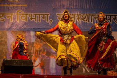 Puşkar, Rajasthan, Hindistan - 11 Kasım 2024: Bhangra, Bhangra grubu, açık hava kültür gecesi renkli etnik elbiseler içinde bhangra dansı yapıyor.