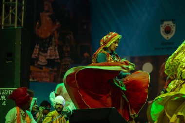 Puşkar, Rajasthan, Hindistan - 11 Kasım 2024: Bhangra, Bhangra grubu, açık hava kültür gecesi renkli etnik elbiseler içinde bhangra dansı yapıyor.