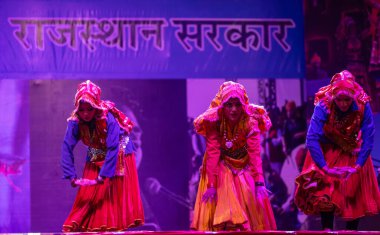 Pushkar, Rajasthan, Hindistan - 11 Kasım 2024: Bhangra, Sih erkek sanatçılar grubu renkli etnik elbiseler içinde bhangra dansı yapıyorlar..