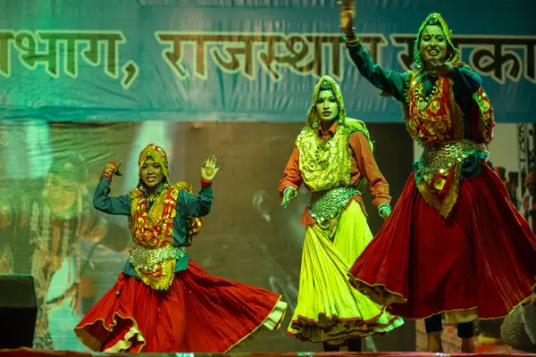 Pushkar, Rajasthan, Hindistan - 11 Kasım 2024: Bhangra, Sih erkek sanatçılar grubu renkli etnik elbiseler içinde bhangra dansı yapıyorlar..