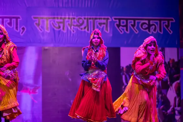 Pushkar, Rajasthan, Hindistan - 11 Kasım 2024: Bhangra, Sih erkek sanatçılar grubu renkli etnik elbiseler içinde bhangra dansı yapıyorlar..