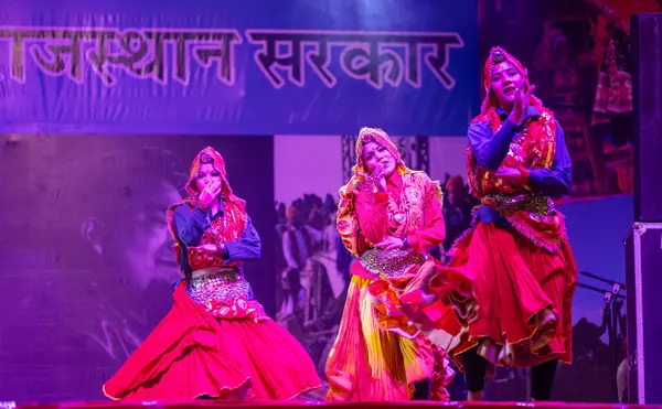 Pushkar, Rajasthan, Hindistan - 11 Kasım 2024: Bhangra, Sih erkek sanatçılar grubu renkli etnik elbiseler içinde bhangra dansı yapıyorlar..