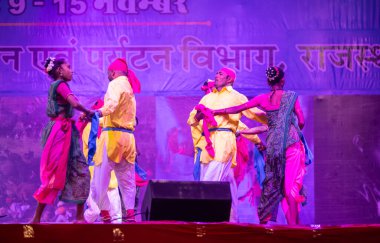 Pushkar, Rajasthan, Hindistan - 11 Kasım 2024: Bhangra, Sih erkek sanatçılar grubu renkli etnik elbiseler içinde bhangra dansı yapıyorlar..