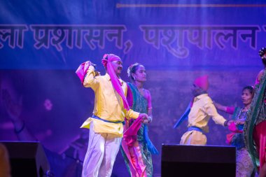 Pushkar, Rajasthan, Hindistan - 11 Kasım 2024: Bhangra, Sih erkek sanatçılar grubu renkli etnik elbiseler içinde bhangra dansı yapıyorlar..