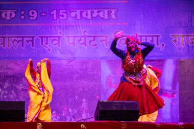Pushkar, Rajasthan, Hindistan - 11 Kasım 2024: Bhangra, Sih erkek sanatçılar grubu renkli etnik elbiseler içinde bhangra dansı yapıyorlar..