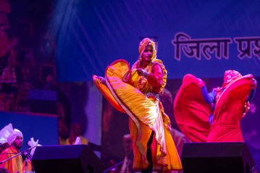 Puşkar, Rajasthan, Hindistan - 11 Kasım 2024: Halk dansı, Hintli erkek ve kadın sanatçılardan oluşan bir grup, Chhattisgarh eyaletinin rengarenk etnik kıyafetleriyle sokak dansı yapıyorlar.