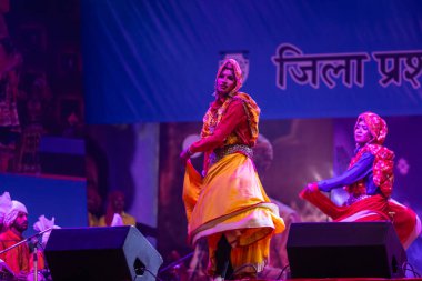 Puşkar, Rajasthan, Hindistan - 11 Kasım 2024: Halk dansı, Hintli erkek ve kadın sanatçılardan oluşan bir grup, Chhattisgarh eyaletinin rengarenk etnik kıyafetleriyle sokak dansı yapıyorlar.