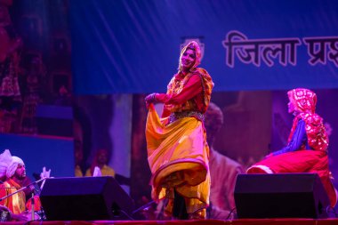 Puşkar, Rajasthan, Hindistan - 11 Kasım 2024: Halk dansı, Hintli erkek ve kadın sanatçılardan oluşan bir grup, Chhattisgarh eyaletinin rengarenk etnik kıyafetleriyle sokak dansı yapıyorlar.