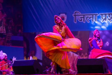 Puşkar, Rajasthan, Hindistan - 11 Kasım 2024: Halk dansı, Hintli erkek ve kadın sanatçılardan oluşan bir grup, Chhattisgarh eyaletinin rengarenk etnik kıyafetleriyle sokak dansı yapıyorlar.