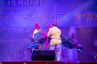 Puşkar, Rajasthan, Hindistan - 11 Kasım 2024: Halk dansı, Hintli erkek ve kadın sanatçılardan oluşan bir grup, Chhattisgarh eyaletinin rengarenk etnik kıyafetleriyle sokak dansı yapıyorlar.