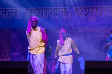 Puşkar, Rajasthan, Hindistan - 11 Kasım 2024: Halk dansı, Hintli erkek ve kadın sanatçılardan oluşan bir grup, Chhattisgarh eyaletinin rengarenk etnik kıyafetleriyle sokak dansı yapıyorlar.