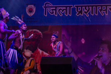 Puşkar, Rajasthan, Hindistan - 11 Kasım 2024: Halk dansı, Hintli erkek ve kadın sanatçılardan oluşan bir grup, Chhattisgarh eyaletinin rengarenk etnik kıyafetleriyle sokak dansı yapıyorlar.