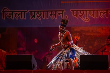 Puşkar, Rajasthan, Hindistan - 11 Kasım 2024: Halk dansı, Hintli erkek ve kadın sanatçılardan oluşan bir grup, Chhattisgarh eyaletinin rengarenk etnik kıyafetleriyle sokak dansı yapıyorlar.