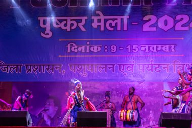 Puşkar, Rajasthan, Hindistan - 11 Kasım 2024: Folk dance, Afrika kıtasından bir grup erkek sanatçı geleneksel kabile kıyafetleriyle kültürel ateş dansı yapıyorlar..