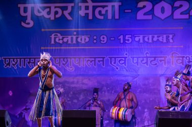 Puşkar, Rajasthan, Hindistan - 11 Kasım 2024: Folk dance, Afrika kıtasından bir grup erkek sanatçı geleneksel kabile kıyafetleriyle kültürel ateş dansı yapıyorlar..