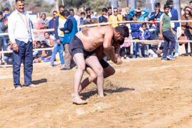 Bikaner, Rajasthan, Hindistan - 15 Ocak 2023: Bikaner festivali, Hint güreşçiler, bikaner festivali sırasında kum tabanında dostça bir maç olarak güreş veya kushti oynuyorlar.