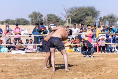 Bikaner, Rajasthan, Hindistan - 15 Ocak 2023: Bikaner festivali, Hint güreşçiler, bikaner festivali sırasında kum tabanında dostça bir maç olarak güreş veya kushti oynuyorlar.