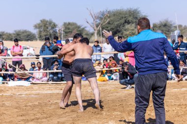 Bikaner, Rajasthan, Hindistan - 15 Ocak 2023: Bikaner festivali, Hint güreşçiler, bikaner festivali sırasında kum tabanında dostça bir maç olarak güreş veya kushti oynuyorlar.