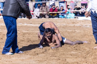 Bikaner, Rajasthan, Hindistan - 15 Ocak 2023: Bikaner festivali, Hint güreşçiler, bikaner festivali sırasında kum tabanında dostça bir maç olarak güreş veya kushti oynuyorlar.