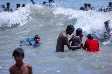 Kulashekharapatnam, Tamilnadu, Hindistan - 12 Ekim 2024: Kulasai Dasara, bir grup çocuk ve ebeveynleri kulasai dasara festivalinde deniz dalgalarının keyfini çıkarıyorlar.