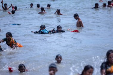 Kulashekharapatnam, Tamilnadu, Hindistan - 12 Ekim 2024: Kulasai Dasara, bir grup çocuk ve ebeveynleri kulasai dasara festivalinde deniz dalgalarının keyfini çıkarıyorlar.