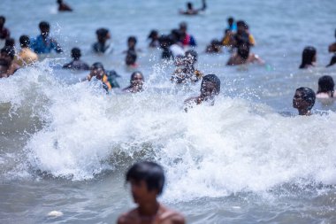 Kulashekharapatnam, Tamilnadu, Hindistan - 12 Ekim 2024: Kulasai Dasara, bir grup çocuk ve ebeveynleri kulasai dasara festivalinde deniz dalgalarının keyfini çıkarıyorlar.