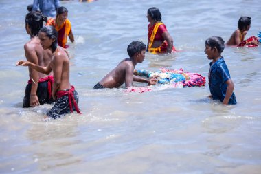 Kulashekharapatnam, Tamilnadu, Hindistan - 12 Ekim 2024: Kulasai Dasara, bir grup çocuk ve ebeveynleri kulasai dasara festivalinde deniz dalgalarının keyfini çıkarıyorlar.