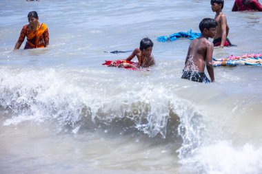 Kulashekharapatnam, Tamilnadu, Hindistan - 12 Ekim 2024: Kulasai Dasara, bir grup çocuk ve ebeveynleri kulasai dasara festivalinde deniz dalgalarının keyfini çıkarıyorlar.