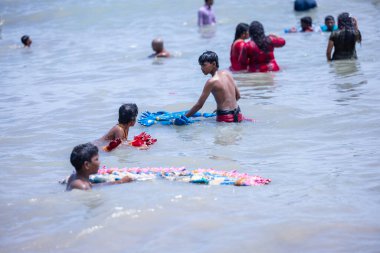 Kulashekharapatnam, Tamilnadu, Hindistan - 12 Ekim 2024: Kulasai Dasara, bir grup çocuk ve ebeveynleri kulasai dasara festivalinde deniz dalgalarının keyfini çıkarıyorlar.