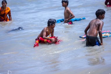 Kulashekharapatnam, Tamilnadu, Hindistan - 12 Ekim 2024: Kulasai Dasara, bir grup çocuk ve ebeveynleri kulasai dasara festivalinde deniz dalgalarının keyfini çıkarıyorlar.