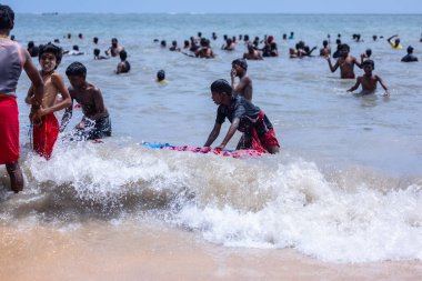 Kulashekharapatnam, Tamilnadu, Hindistan - 12 Ekim 2024: Kulasai Dasara, bir grup çocuk ve ebeveynleri kulasai dasara festivalinde deniz dalgalarının keyfini çıkarıyorlar.