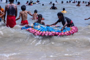 Kulashekharapatnam, Tamilnadu, Hindistan - 12 Ekim 2024: Kulasai Dasara, bir grup çocuk ve ebeveynleri kulasai dasara festivalinde deniz dalgalarının keyfini çıkarıyorlar.